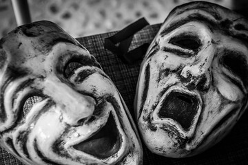 Pair of eerie masks on a textile background in grayscale