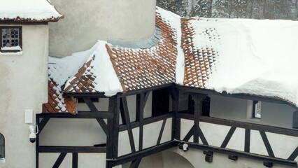 Snow blown from red roofs of the medieval castle at snow blizzard