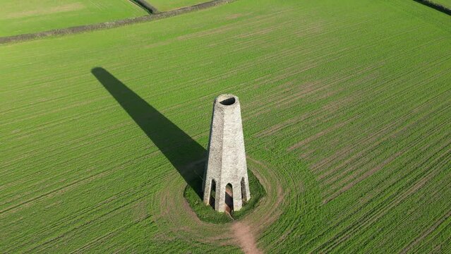 Aerial of the Daymark tower in Kingswear, England standing in the middle of a green field
