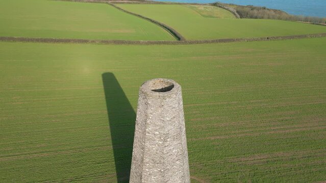 Aerial of the Daymark tower in Kingswear, England standing in the middle of a green field