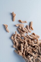 Variety of cooked pasta pieces of different shapes and sizes arranged on a light-colored surface
