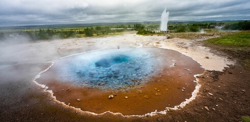 Aerial view of a geyser in the middle of a sprawling landscape in Iceland - obrazy, fototapety, plakaty