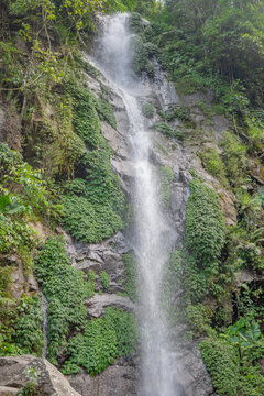 Small water fall on the tropical forest when rain season. The photo is suitable to use for adventure content media, nature poster and forest background.
