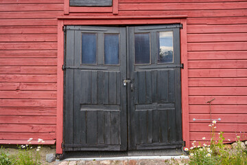 Old black wooden double doors in historical building in Finland.