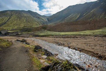 Scenic view of a mountain range with a small creek in the foreground. Landmannalaugar, Iceland.