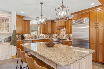 Modern kitchen with a granite island countertop and wooden cabinetry. - obrazy, fototapety, plakaty