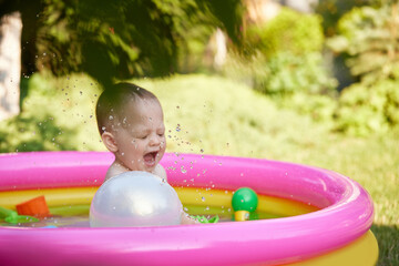 cute baby girl swimming in kid inflatable pool