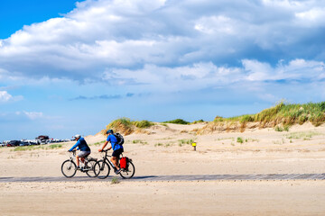 Fototapeta na wymiar Cyclists on the beach of Sankt Peter Ording, North Sea, Germany