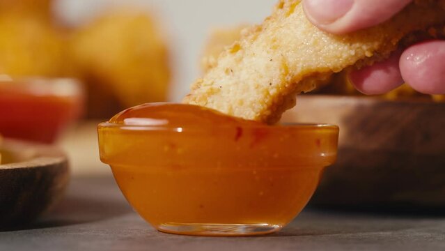 Man eating Fast food delivery meals chicken nuggets with sweet chilli sauce tomato ketchup, and fried chicken french fries, on wooden table ready to takeaway. Fat American cuisine.