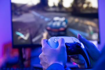 Selective focus at hand playing online game on computer monitor and smartphone with colorful gaming light decoration inside of the room. Gamer concept, game creator that live broadcast on platform © BritCats Studio