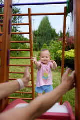 Fototapeta na wymiar little baby girl with mother on slide in playground