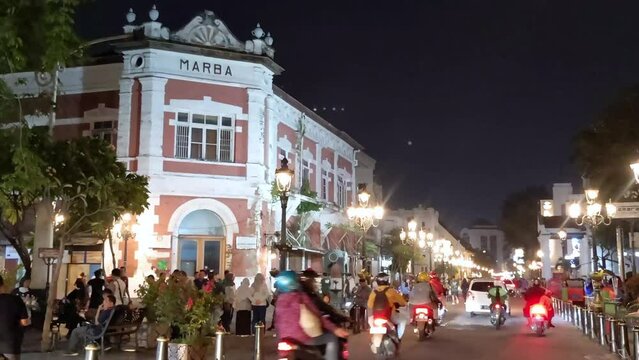 Time lapse and unfocused night shot of the ambience visitors around old Dutch colonial buildings in historic district of Semarang City, Central Java, Indonesia