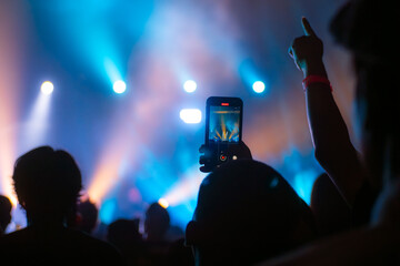 crowd holding smart phone and recording and photographing in concert , silhouette of hands with mobile , event background concept