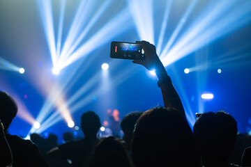 People holding smart phone and recording and photographing in concert , silhouette of hands with mobile , event background concept