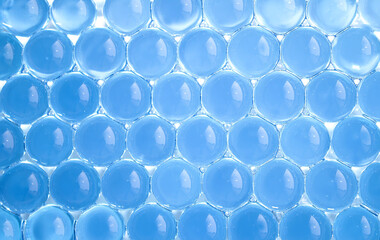 Macro of light blue gel balls. Watery polymer hydrogel background. Crystal liquid. Transparent...
