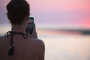 Girl Shooting sunset on the mobile phone