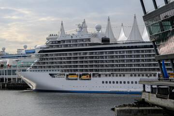 View onto ultra luxury all inclusive white Regent cruiseship cruise ship liner Explorer in port of Vancouver, Canada at terminal for Alaska cruising during twilight early morning	