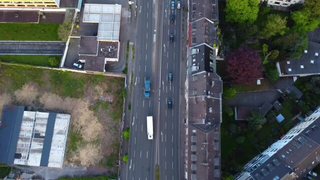 Drone aerial shot of city streets in Dusseldorf Germany with residential buildings, traffic, cars, street trams, people, commercial space, houses in the early morning at sunrise. Urban flight 