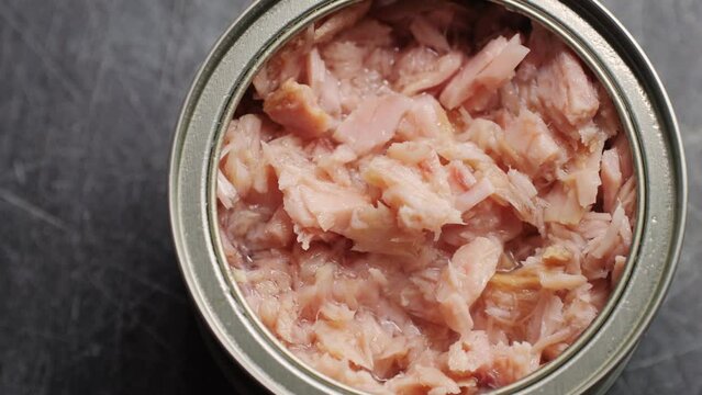 Opening tuna can, man open the canned tuna on the table. Close up on professional kitchen.