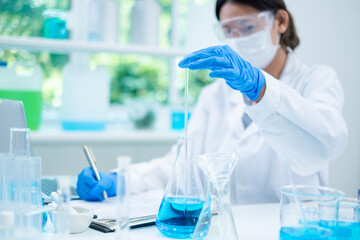 Fototapeta premium A female scientist is checking a temperature of substance in laboratory. Concept of checking the quality of sample liquid or biotechnology and medicine research, examining, inspection or discovery.