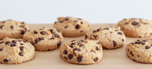 Detail of several homemade chocolate cookies placed on top of wooden kitchen table. Gluten-free.