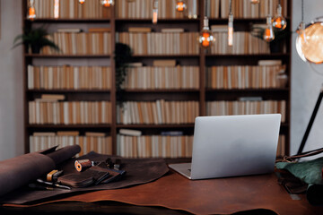 Workplace of tailor leather worker with laptop at workbench. Concept small business