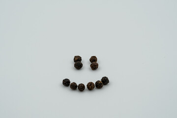 The round black small peppers are piled up and in the shape of smiles