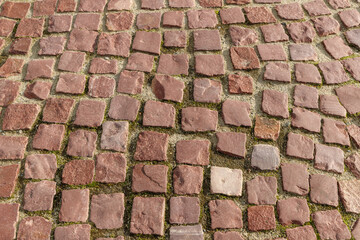 Grunge brown granite tiled walking path. Tiled retro pavement or square in old city.