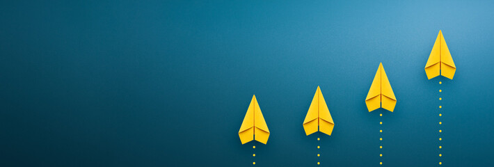 Yellow paper plane on blue background, Success in business growth concept. copy space - obrazy, fototapety, plakaty