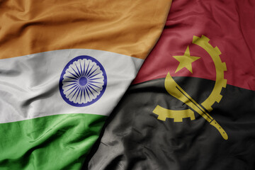 big waving realistic national colorful flag of india and national flag of angola .