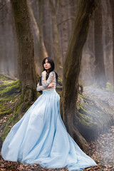 girl in a blue dress in the forest