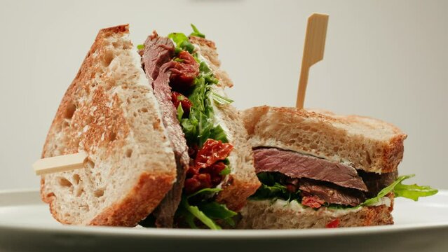 American pastrami sandwich in New York ham meet cuts. chef cooking Famous thick cut sous vide beef sandwich on restaurant cafe kitchen. Studio shot close up, macro, white background. 