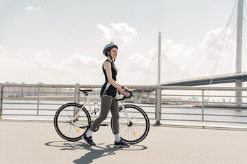 Athlete woman in helmet training bike. A cyclist rides in the city on an eco-transporter. in...