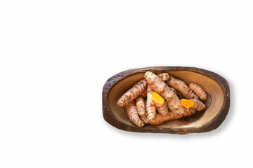 Fresh turmeric roots in a wooden bowl on white background.