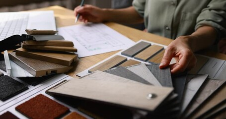 interior designer working on new house design project in office. choosing flooring and furniture materials and colors from samples - Powered by Adobe