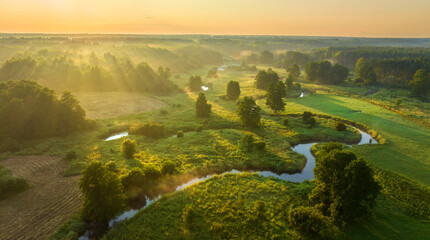 Beautiful summer sunrise over the river covered with morning fog
