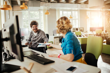 Young people using a computer while working in a startup company office