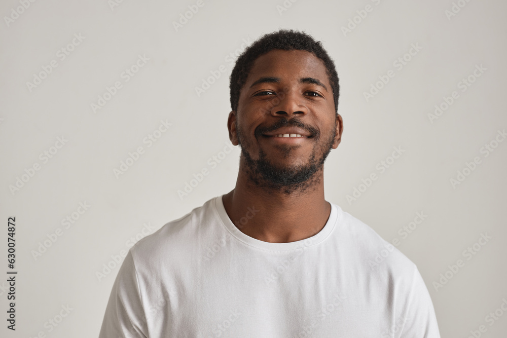 Wall mural minimal portrait of handsome black man posing in studio against white background - Wall murals
