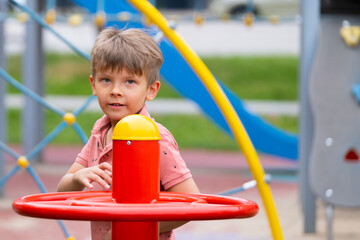 Portrait of six year old boy on playground in summer..