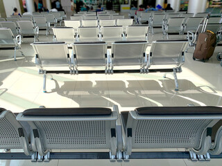 comfortable metal rows of seats in bright airport lounge, Airport waiting room, concept passenger traffic, delay, flight cancellation, arrival time, international voyage, modern furniture
