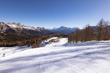 Beautiful alpine panoramic view of snowy mountains, beautiful European winter mountains in Italy Dolomites, lope for cross country skiers and downhill skiers in countryside. Picturesque wintry scene
