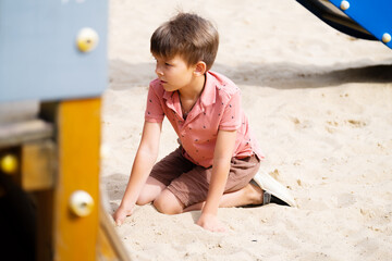 Portrait of six year old boy on playground in summer..