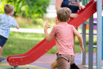 Fototapeta na wymiar Portrait of six year old boy on playground in summer..