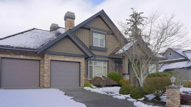 Establishing shot of two story stucco luxury house with big tree and nice landscape at winter in Vancouver, Canada, North America. Day time on January 2023. ProRes 422 HQ.