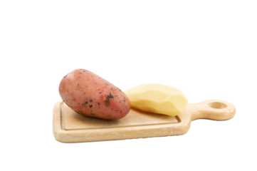 immagine primo piano di patata rossa e patata sbucciata su tagliere in legno, vista dall'alto su sfondo trasparente