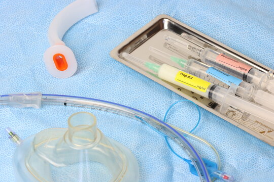 Surgical surface close up view of a endotracheal tube, oxygen mask, Oropharyngeal airway and tray with anesthetic syringes