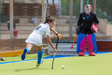 Young female forward hit the ball near the opponents net