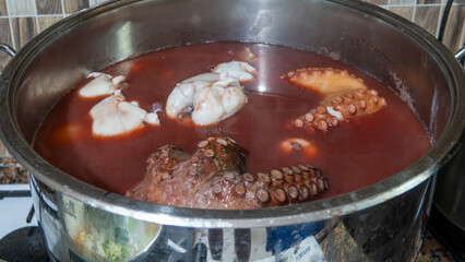 Boiled octopus marinated with various herbs and bay leaves in a large pot