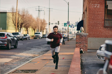 Young man jogging in the city on a street