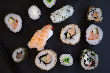 Sushi Assortment And Large Maki On Slate. A Variety Of Japanese Sushi With Rice, Crab, Salmon And Eel Rolls. Top View